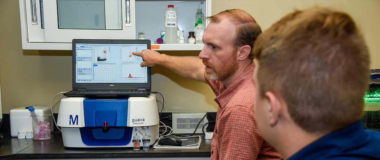 Dr. Geoffrey Mitchell, assistant professor of biology, and Chandler Dickert ’23, a psychology major from Newberry, South Carolina, review data supporting research to save coral reefs.